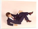 1970s overhead looking down at man lying down legs crossed wearing business suit shrug off hand expression looking at camera by Anonymous
