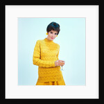 1960s brunette woman short pixie hair style yellow knit sweater earrings holding wine glass by Anonymous