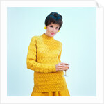 1960s brunette woman short pixie hair style yellow knit sweater earrings holding wine glass by Anonymous