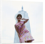 1960s young woman print miniskirt dress summer hat in front empire state building new york city by Anonymous