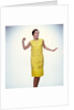 1960s smiling brunette woman modeling yellow sequined cocktail dress clothes by Anonymous