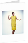 1960s smiling brunette woman modeling yellow sequined cocktail dress clothes by Anonymous