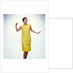 1960s smiling brunette woman modeling yellow sequined cocktail dress clothes by Anonymous