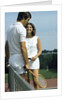 1970s smiling couple standing by net on tennis court holding wood rackets by Anonymous