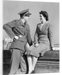 1940s happy couple man wearing army uniform woman sitting on stone wall by Anonymous