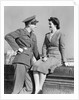 1940s happy couple man wearing army uniform woman sitting on stone wall by Anonymous