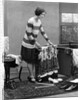 1920s woman packing clothes for travel by Anonymous