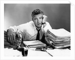 1950s portrait man overworked with desk full of papers by Anonymous