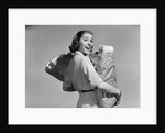 1950s smiling woman carrying grocery bags both hands looking at camera over her shoulder by Anonymous