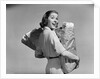 1950s smiling woman carrying grocery bags both hands looking at camera over her shoulder by Anonymous