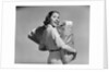 1950s smiling woman carrying grocery bags both hands looking at camera over her shoulder by Anonymous