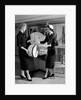 1950s woman in hat stole & gloves taking hatbox from saleswoman by Anonymous