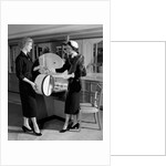 1950s woman in hat stole & gloves taking hatbox from saleswoman by Anonymous