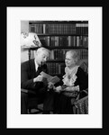1930s 1940s retired senior couple looking at check in living room man smoking pipe by Anonymous