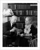 1930s 1940s retired senior couple looking at check in living room man smoking pipe by Anonymous