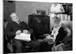 1930s elderly couple sitting in living room listening to radio woman knitting man with newspaper in lap by Anonymous