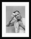 1940s 1950s perspiring man in rolled up shirt sleeves loosening tie holding handkerchief wiping forehead looking at camera by Anonymous