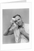 1940s 1950s perspiring man in rolled up shirt sleeves loosening tie holding handkerchief wiping forehead looking at camera by Anonymous