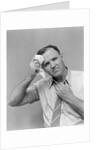 1940s 1950s perspiring man in rolled up shirt sleeves loosening tie holding handkerchief wiping forehead looking at camera by Anonymous