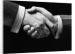 1930s close-up of businessmen's hands in handshake against dark background by Anonymous