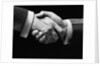1930s close-up of businessmen's hands in handshake against dark background by Anonymous