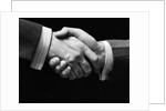 1930s close-up of businessmen's hands in handshake against dark background by Anonymous