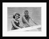 1950s teen couple in swimming pool smiling looking at camera by Anonymous
