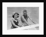 1950s teen couple in swimming pool smiling looking at camera by Anonymous