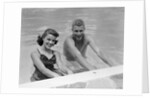 1950s teen couple in swimming pool smiling looking at camera by Anonymous