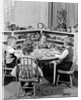 1950s 4 pre-school age children seated at small round table putting together jigsaw puzzle by Anonymous