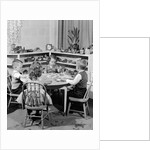 1950s 4 pre-school age children seated at small round table putting together jigsaw puzzle by Anonymous