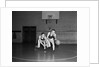1930s two boys playing basketball inside court dribbling basketball by Anonymous