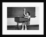 1930s 1940s smiling girl sitting at desk raising her hand by Anonymous