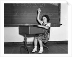 1930s 1940s smiling girl sitting at desk raising her hand by Anonymous