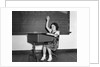 1930s 1940s smiling girl sitting at desk raising her hand by Anonymous