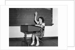 1930s 1940s smiling girl sitting at desk raising her hand by Anonymous
