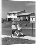 1950s back view of twin girls in plaid skirts & cardigans holding book bags running past school slow sign by Anonymous