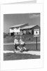 1950s back view of twin girls in plaid skirts & cardigans holding book bags running past school slow sign by Anonymous