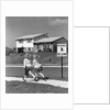 1950s back view of twin girls in plaid skirts & cardigans holding book bags running past school slow sign by Anonymous