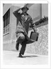 1960s 1950s frantic man running down street holding hat on with hand carrying briefcase wearing top coat by Anonymous