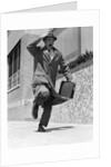 1960s 1950s frantic man running down street holding hat on with hand carrying briefcase wearing top coat by Anonymous