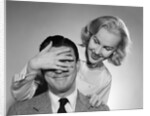 1950s woman standing behind man with hand over his eyes by Anonymous