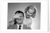 1950s woman standing behind man with hand over his eyes by Anonymous