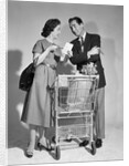 1950s couple man woman shopping cart reviewing grocery list man has cigar in hand by Anonymous