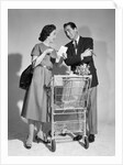 1950s couple man woman shopping cart reviewing grocery list man has cigar in hand by Anonymous
