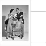 1950s couple man woman shopping cart reviewing grocery list man has cigar in hand by Anonymous