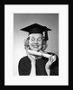 1950s smiling woman teenage girl eyes closed holding diploma graduate wearing cap gown by Anonymous