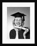 1950s smiling woman teenage girl eyes closed holding diploma graduate wearing cap gown by Anonymous