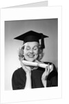 1950s smiling woman teenage girl eyes closed holding diploma graduate wearing cap gown by Anonymous