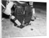 1940s 1950s close-up of padded goalie shown waist-down holding stick with puck in front of him by Anonymous
